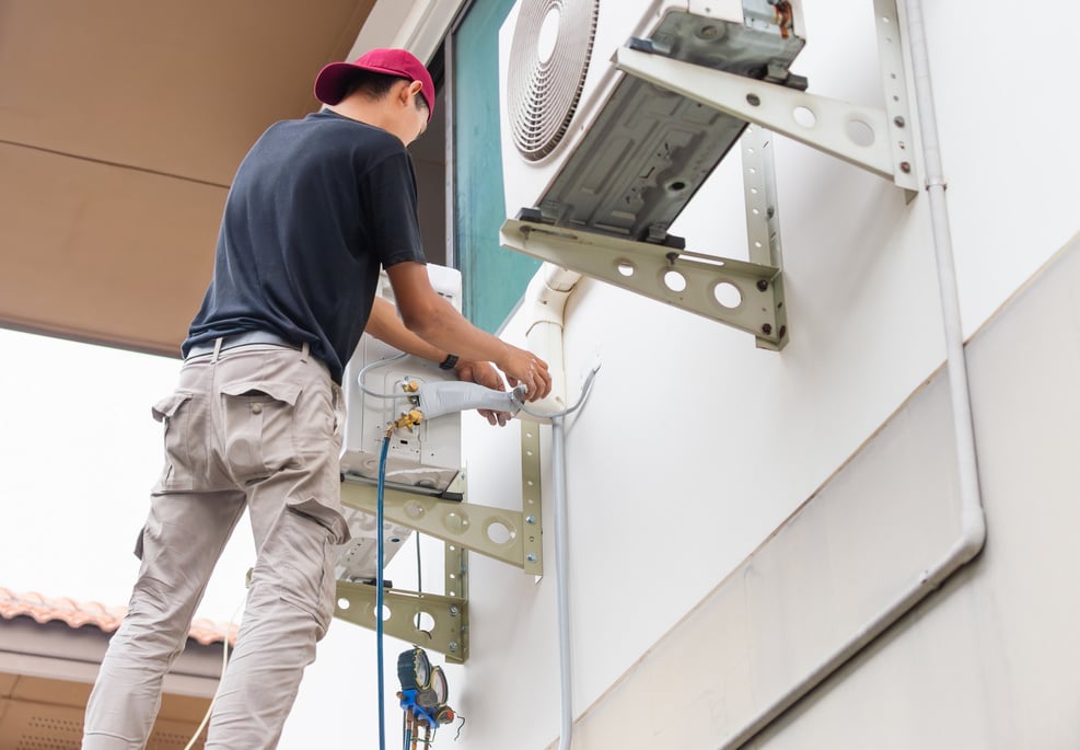 Air Conditioning Repairman checking and fixing modern air condit