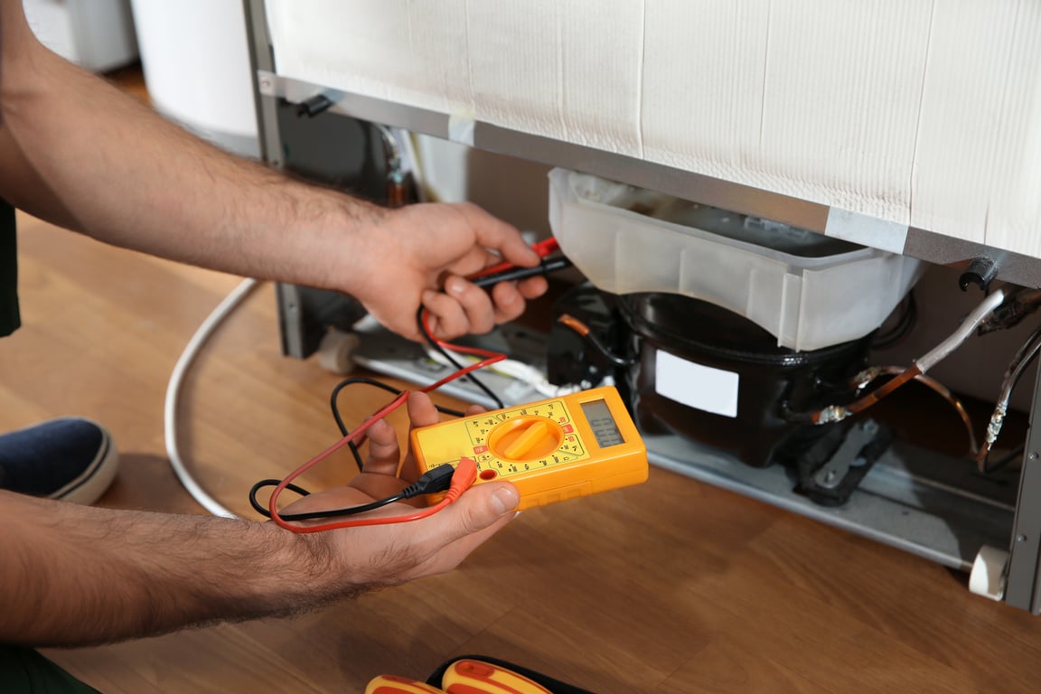 Male Technician Repairing Broken Refrigerator Indoors, Closeup